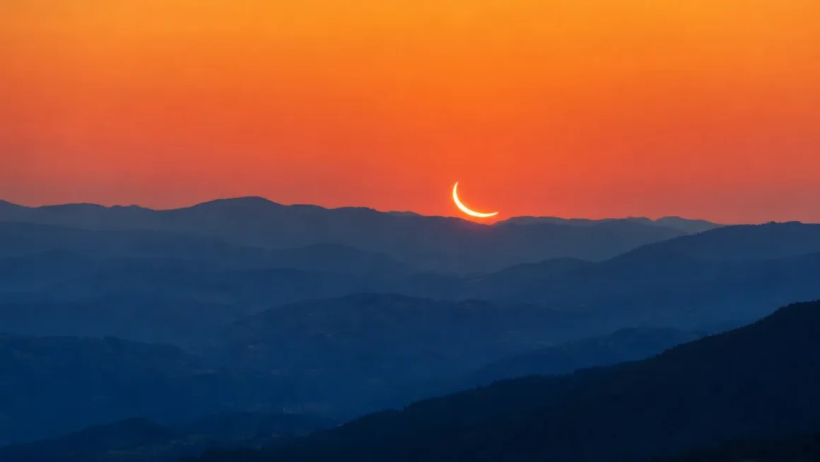 Močno zakrito Sonce nizko nad zahodnim obzorjem v Sloveniji