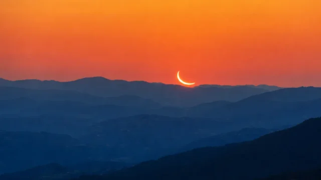 Močno zakrito Sonce nizko nad zahodnim obzorjem v Sloveniji