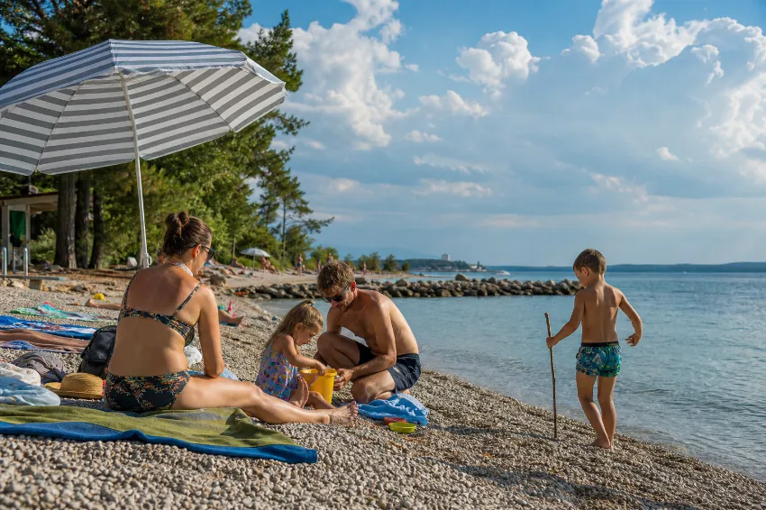 Družina na slovenski obali zadnji vikend avgusta, nad morjem se kopičijo kopasti oblaki